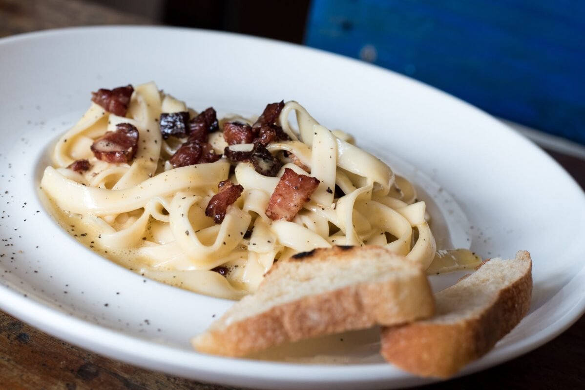 pasta dish with bread on white ceramic plate