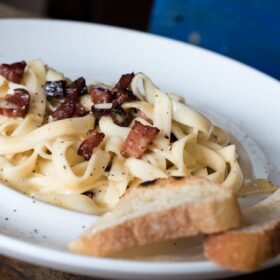 pasta dish with bread on white ceramic plate