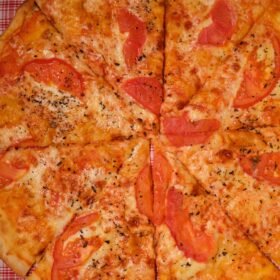 pizza slices with tomatoes on table