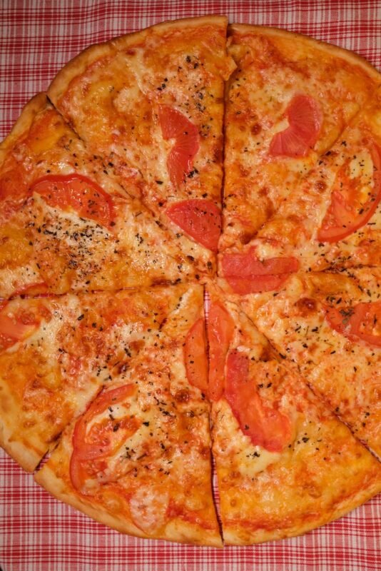 pizza slices with tomatoes on table