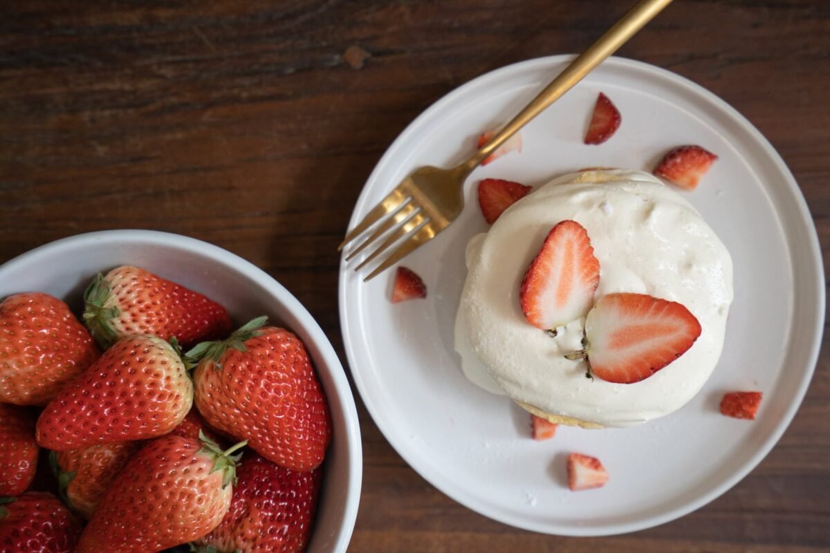 strawberries on white ceramic bowl and whipped cream