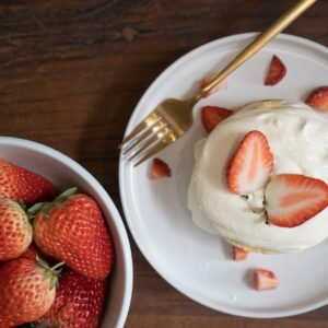 strawberries on white ceramic bowl and whipped cream
