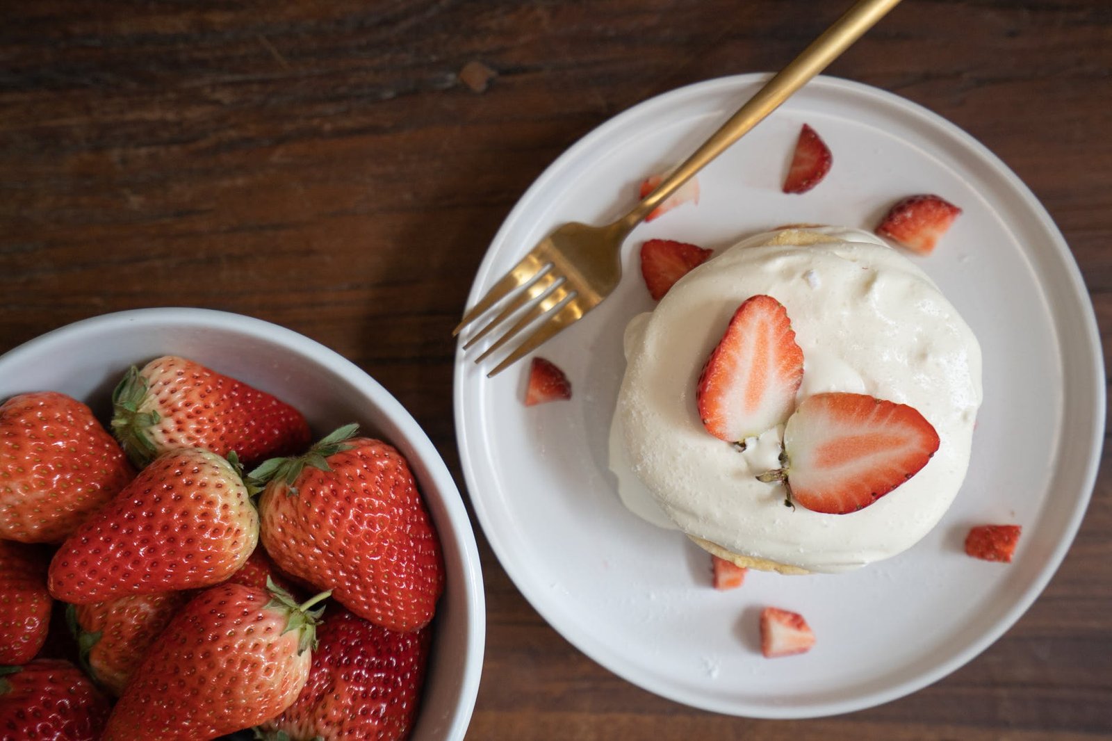 strawberries on white ceramic bowl and whipped cream