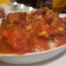 Baked pork chop in tomato sauce on rice