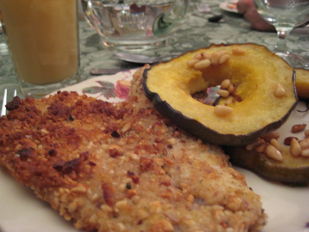 Nut-crusted tilapia with acorn squash rings and pine nuts